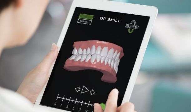 Dentista a examinar uma simulação 3D de uma dentição antes e depois do tratamento DR SMILE